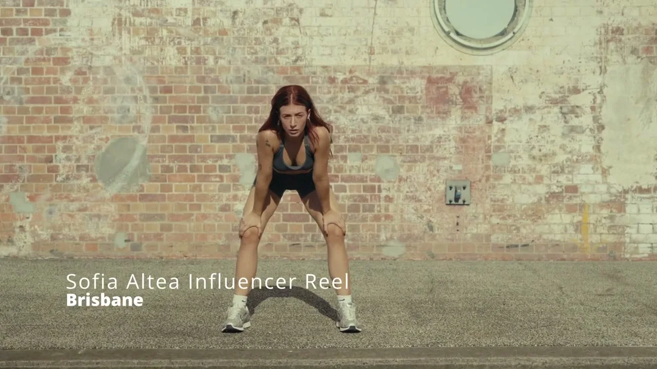 Athlete catching her breath against a weathered brick wall