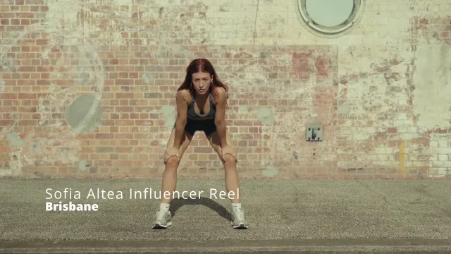 Athlete catching her breath against a weathered brick wall